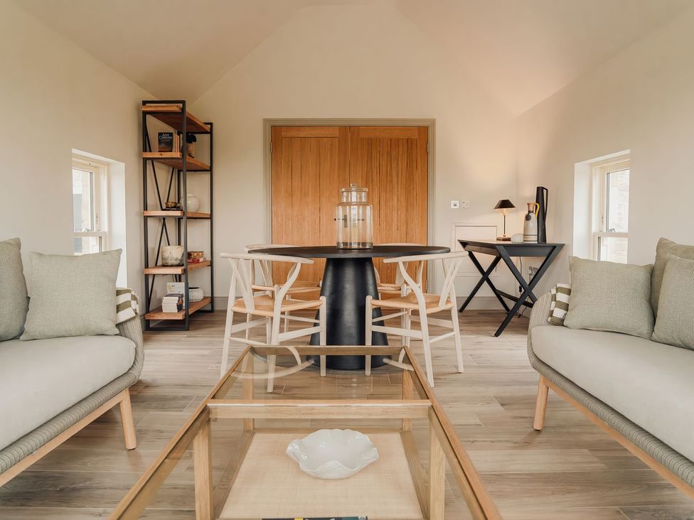 A living room with a table and chairs at Mill Farm House in Beadnell