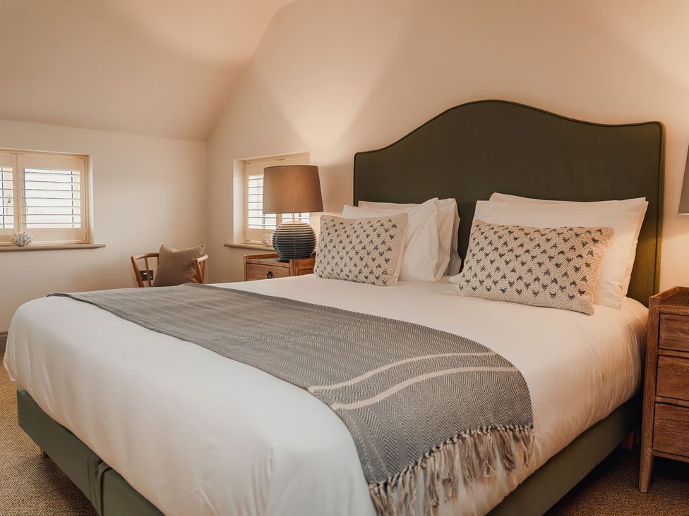A bedroom with a bed and bedside table at Mill Farm House Beadnell