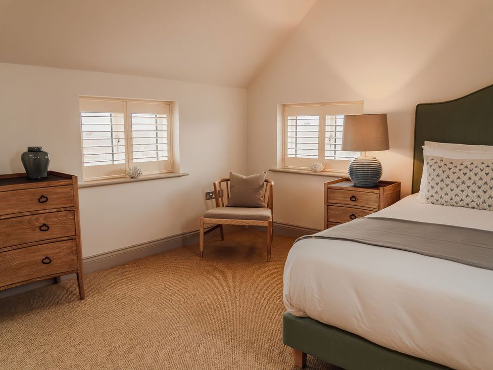 A bedroom with a bed and nightstands at Mill Farm House in Beadnell