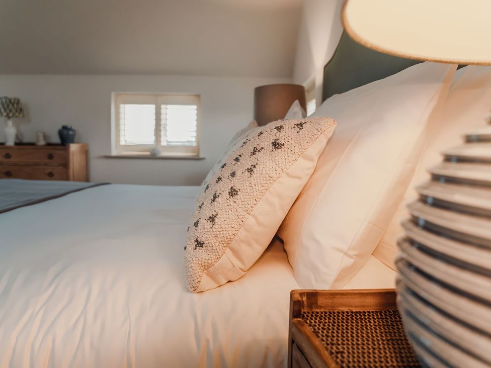 A bedroom with a bed and pillows at Mill Farm House in Beadnell