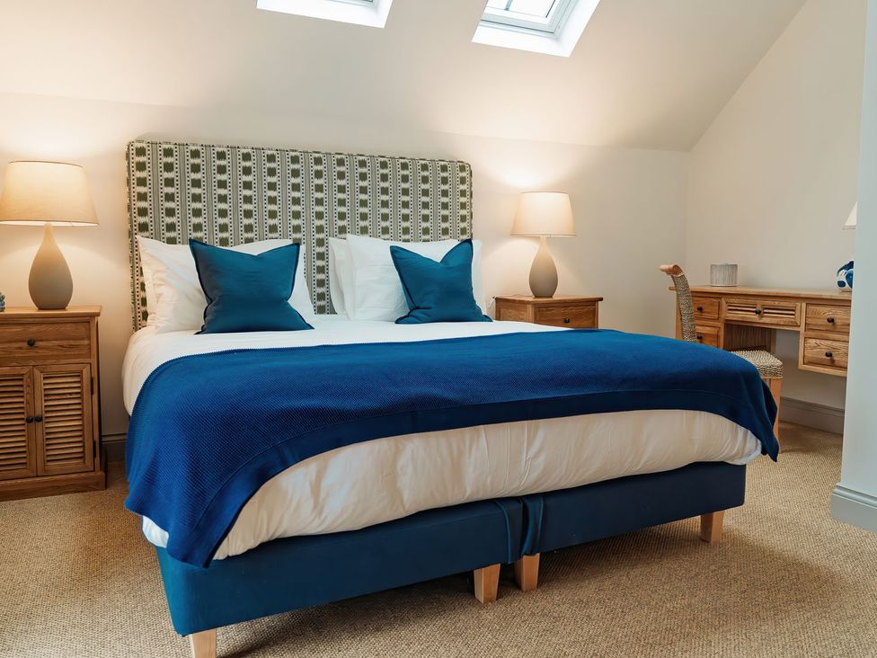 A bedroom with a bed and bedside tables at Mill Farm House Beadnell
