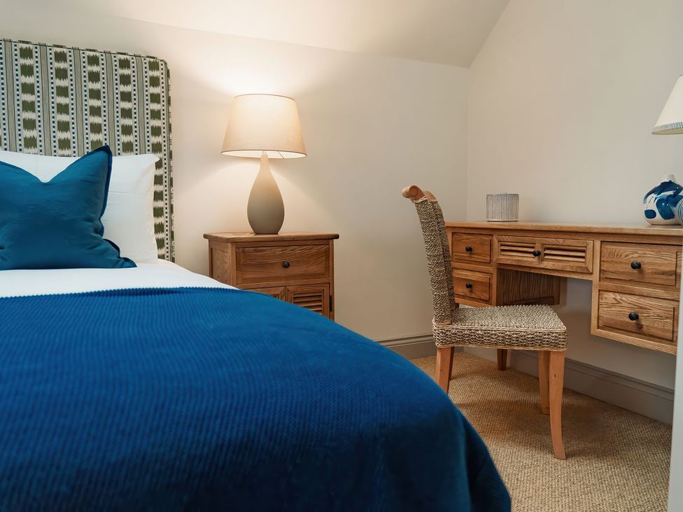 A bedroom with a bed and desk at Mill Farm House in Beadnell