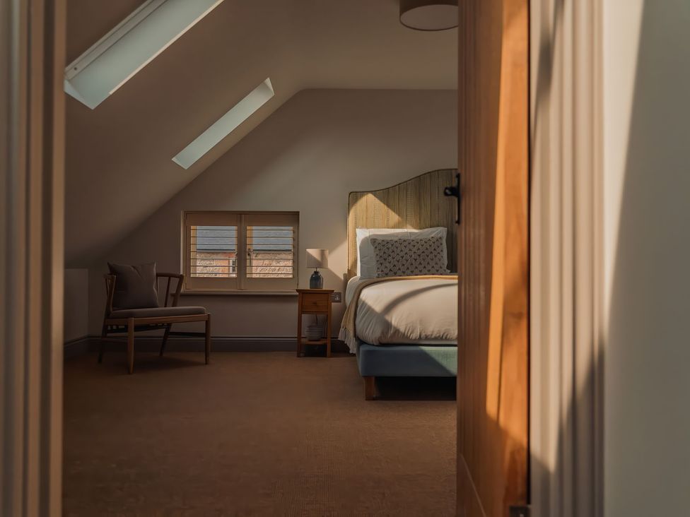 A bedroom with a bed and chair at Mill Farm House Beadnell