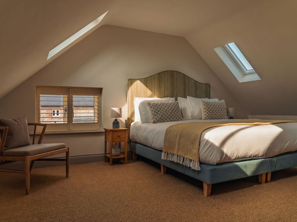 A bedroom with a bed and chair at Mill Farm House in Beadnell