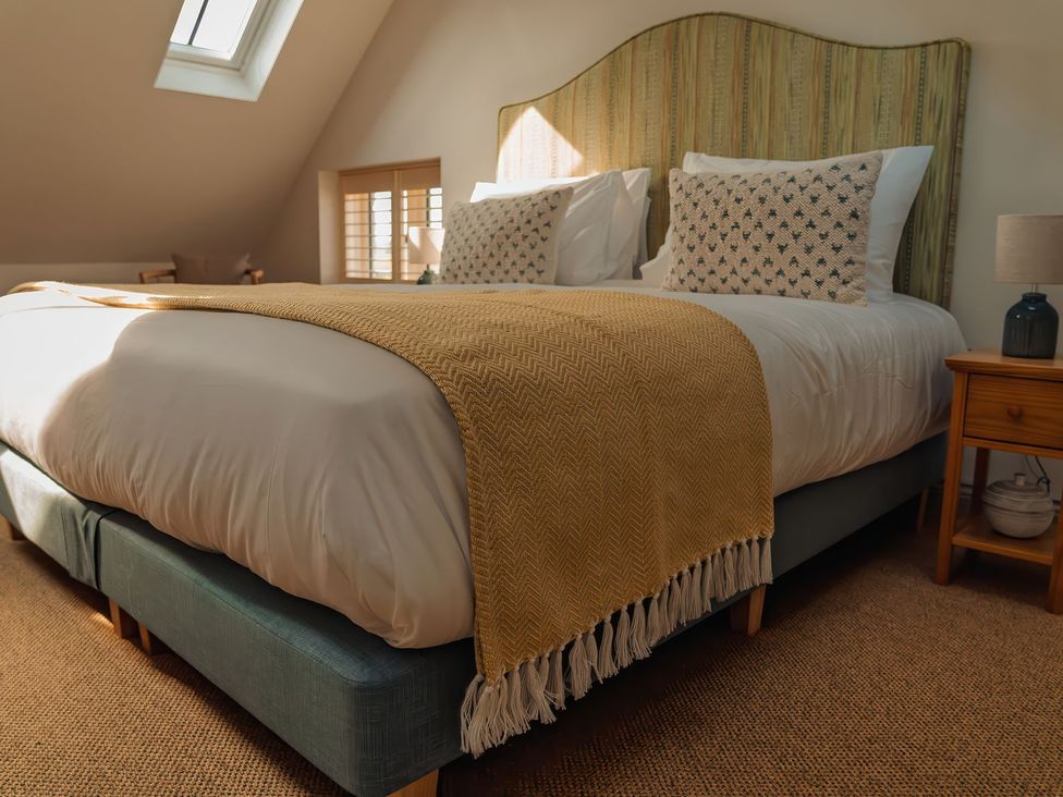 A bedroom with a bed and bedside table at Mill Farm House Beadnell