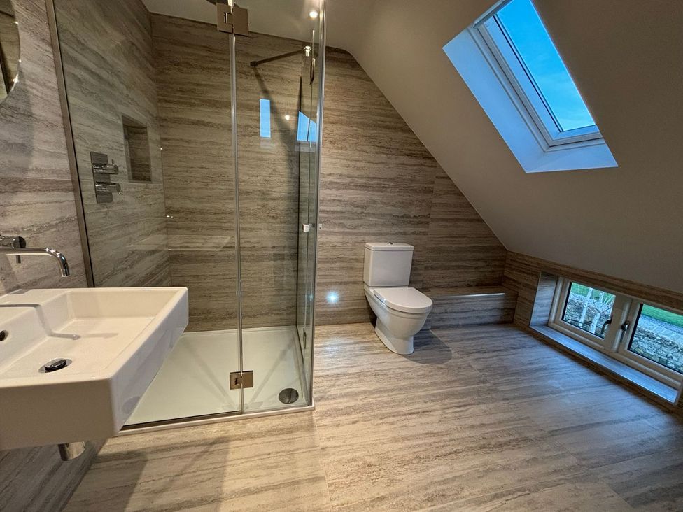 A bathroom with a shower, toilet, and sink at Mill Farm House in Beadnell