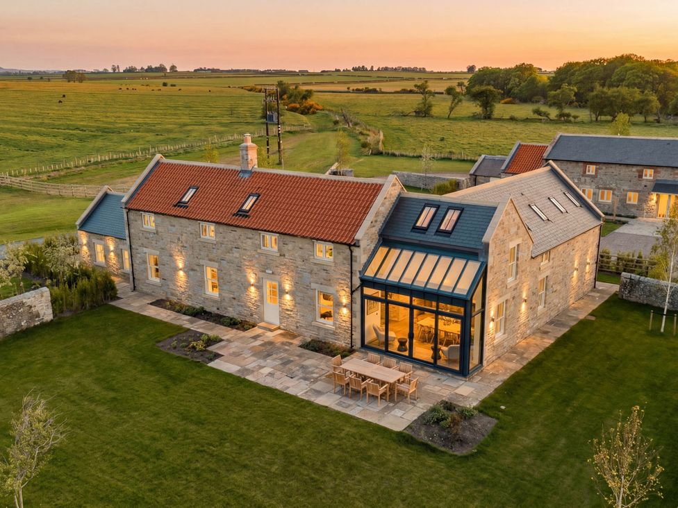 An exterior view of a stone house with a garden at Mill Farm House Beadnell