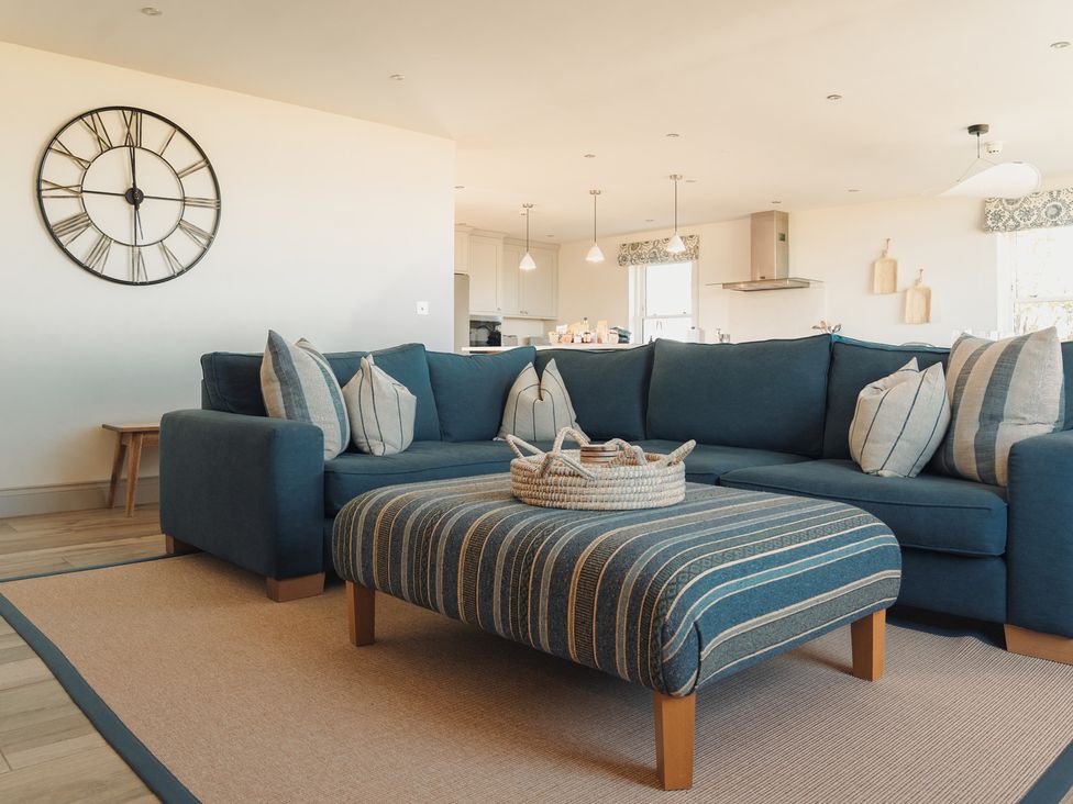 A living room with a blue sofa and a coffee table at Mill Farm House in Beadnell