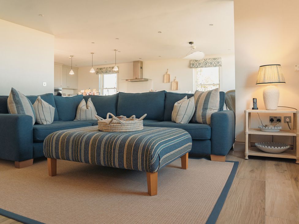 A living room with a sofa and ottoman at Mill Farm House Beadnell