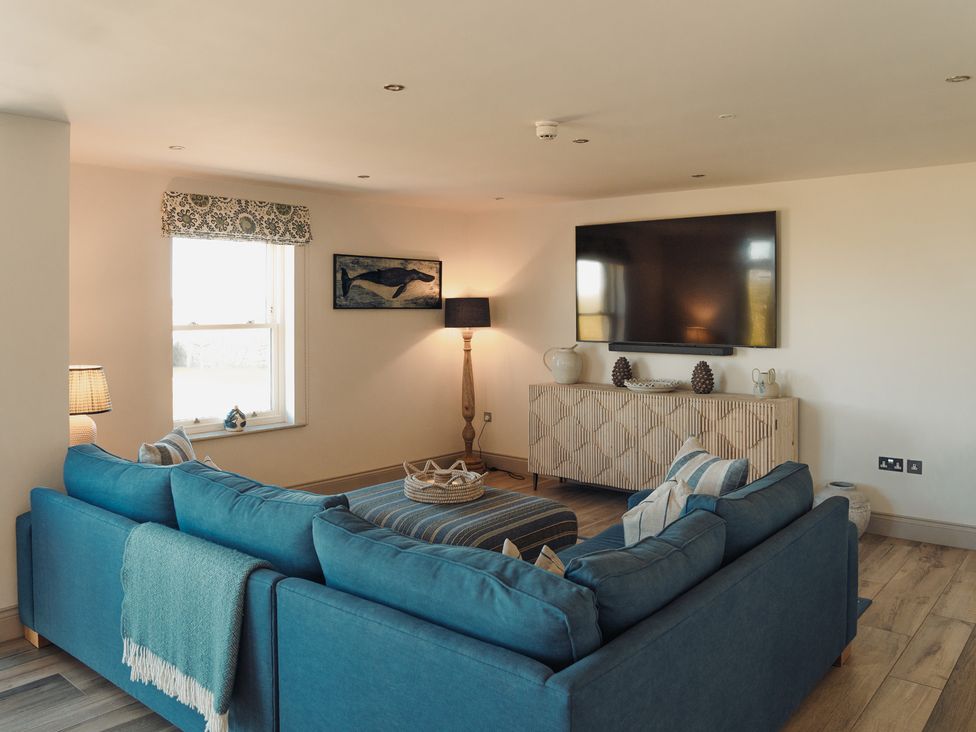 A living room with a sofa and television at Mill Farm House in Beadnell