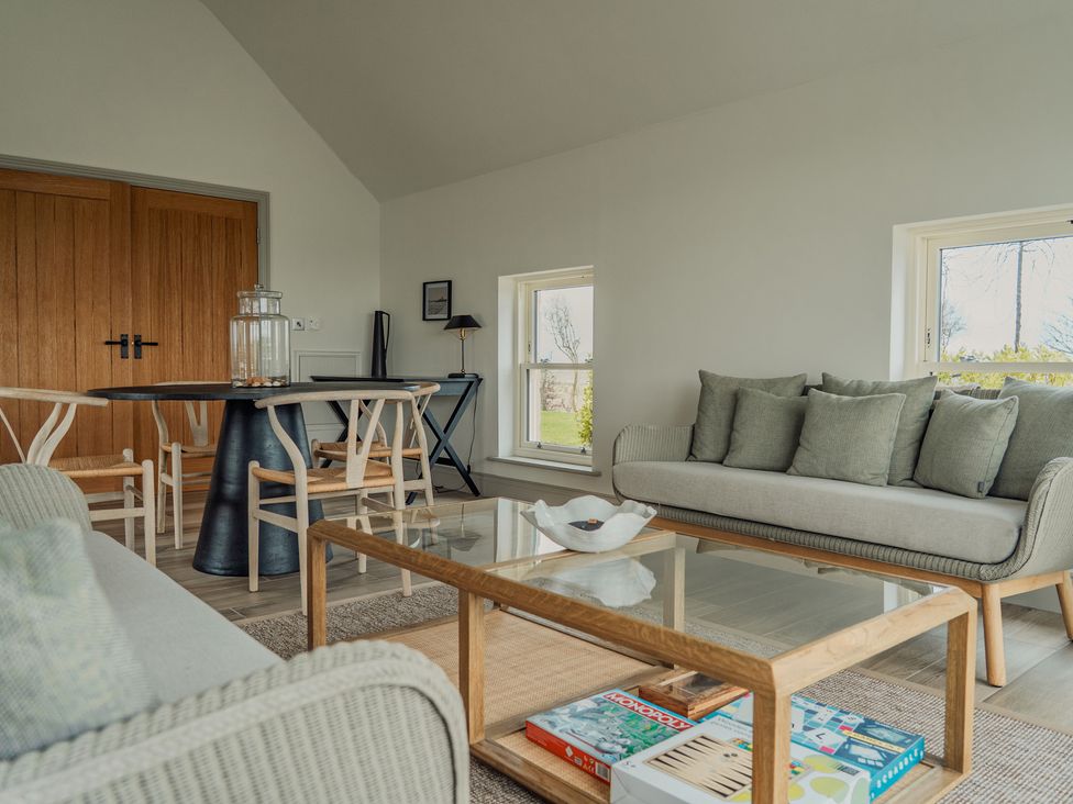 A living room with seating and a dining table at Mill Farm House in Beadnell