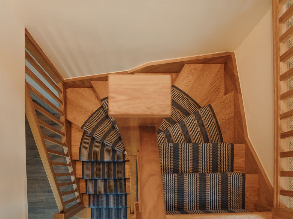 A staircase with wooden steps and carpet at Mill Farm House in Beadnell