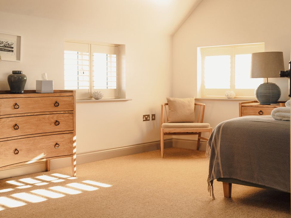 A bedroom with a bed and chair at Mill Farm House Beadnell