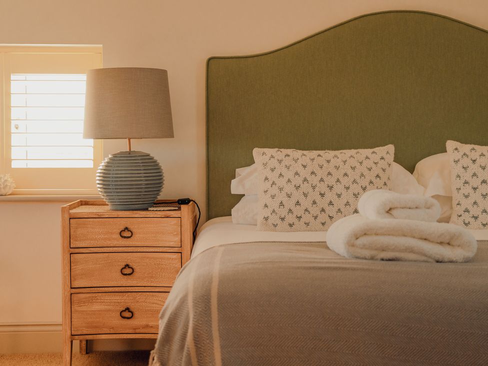 A bedroom with a bed and bedside table at Mill Farm House Beadnell