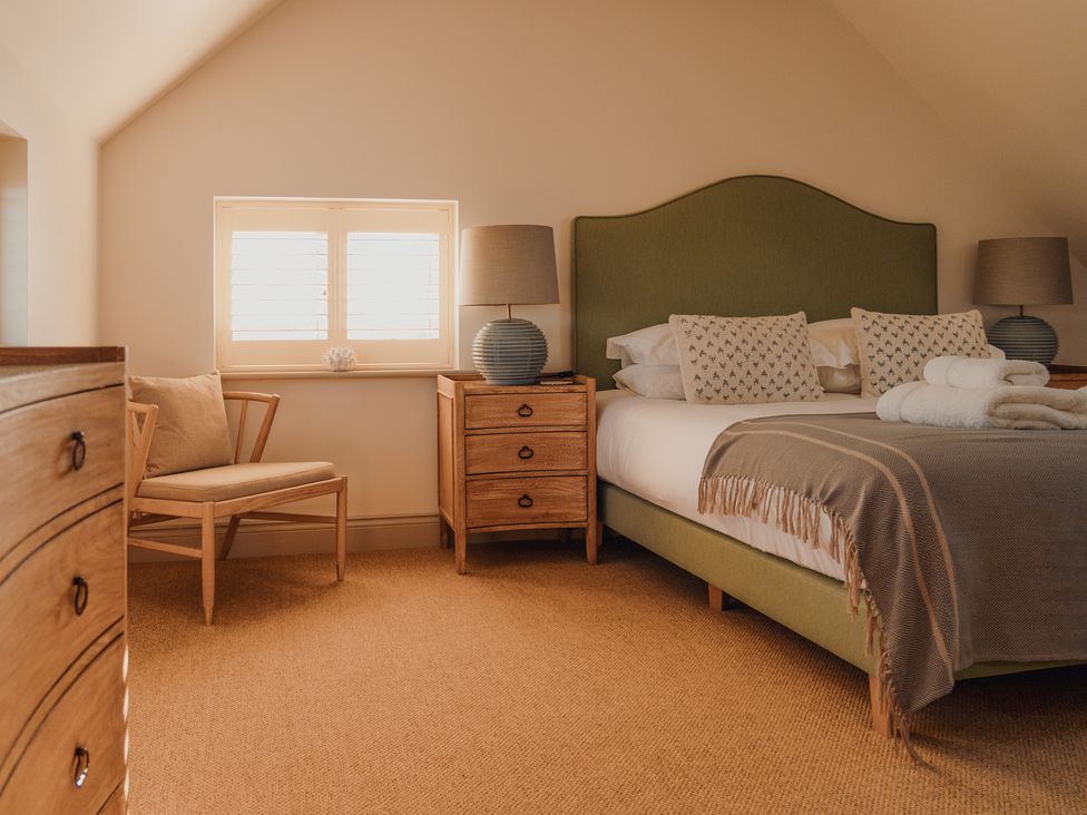 A bedroom with a bed and nightstand at Mill Farm House, Beadnell