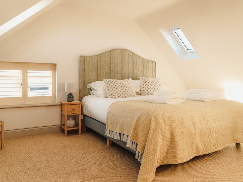 A bedroom with a bed and bedside table at Mill Farm House Beadnell