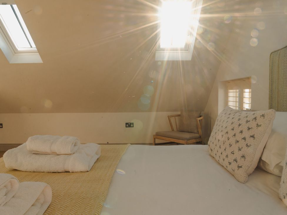 A bedroom with bed and towels at Mill Farm House, Beadnell
