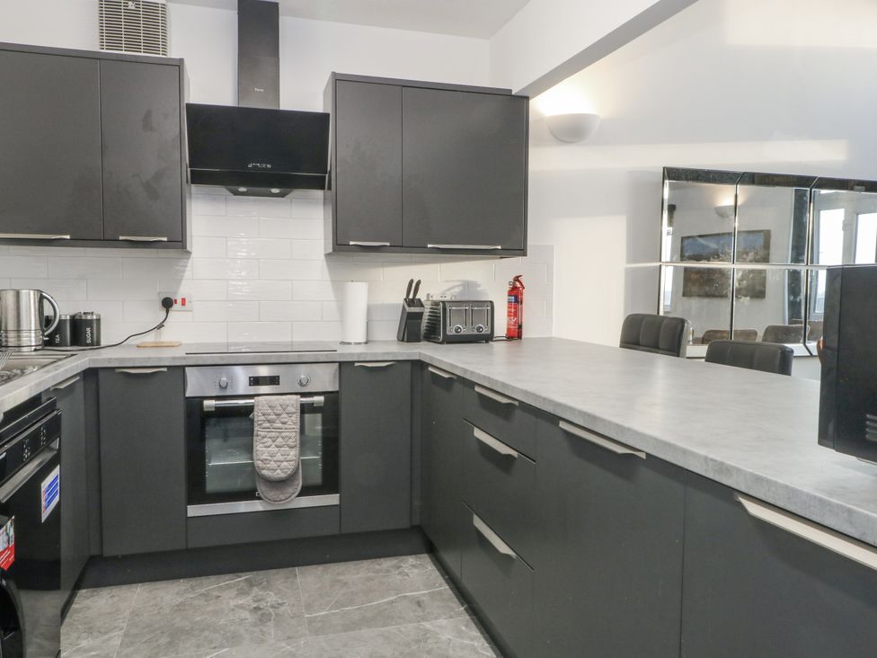 A kitchen with modern cabinets and appliances at Manchester apartment in Manchester