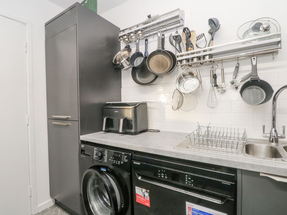 A kitchen with appliances and utensils at Manchester apartment in Manchester