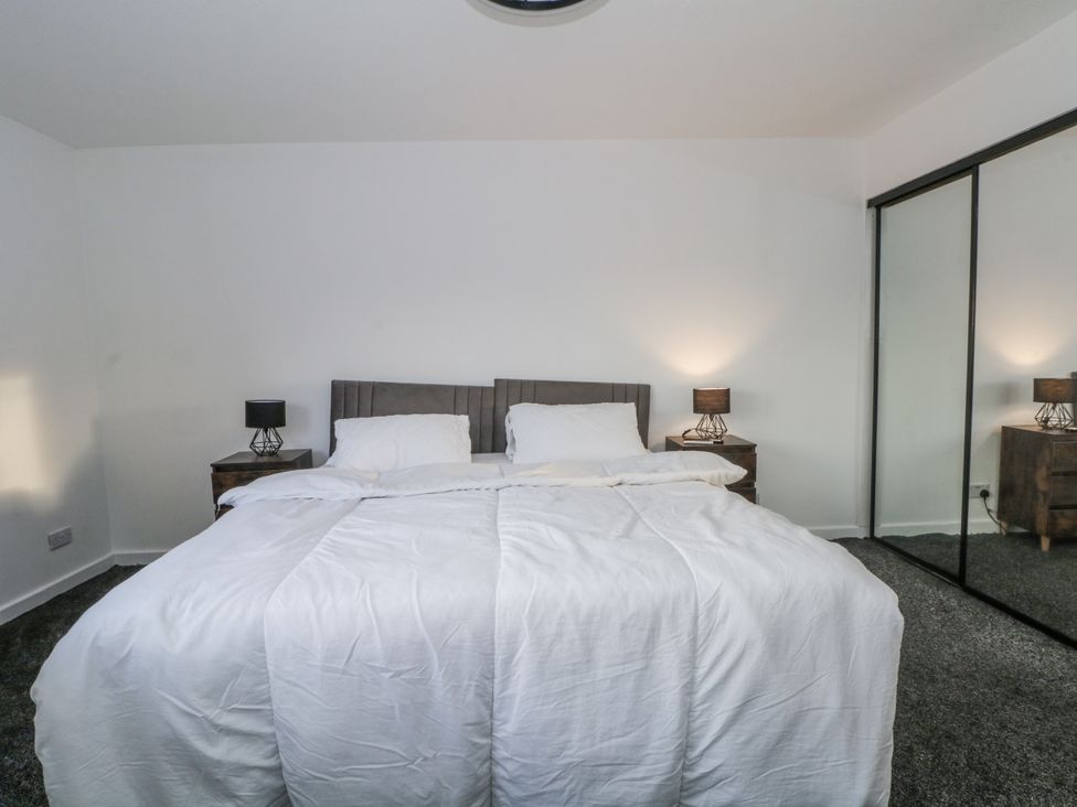 A bedroom with a bed and nightstands at Manchester apartment in Manchester