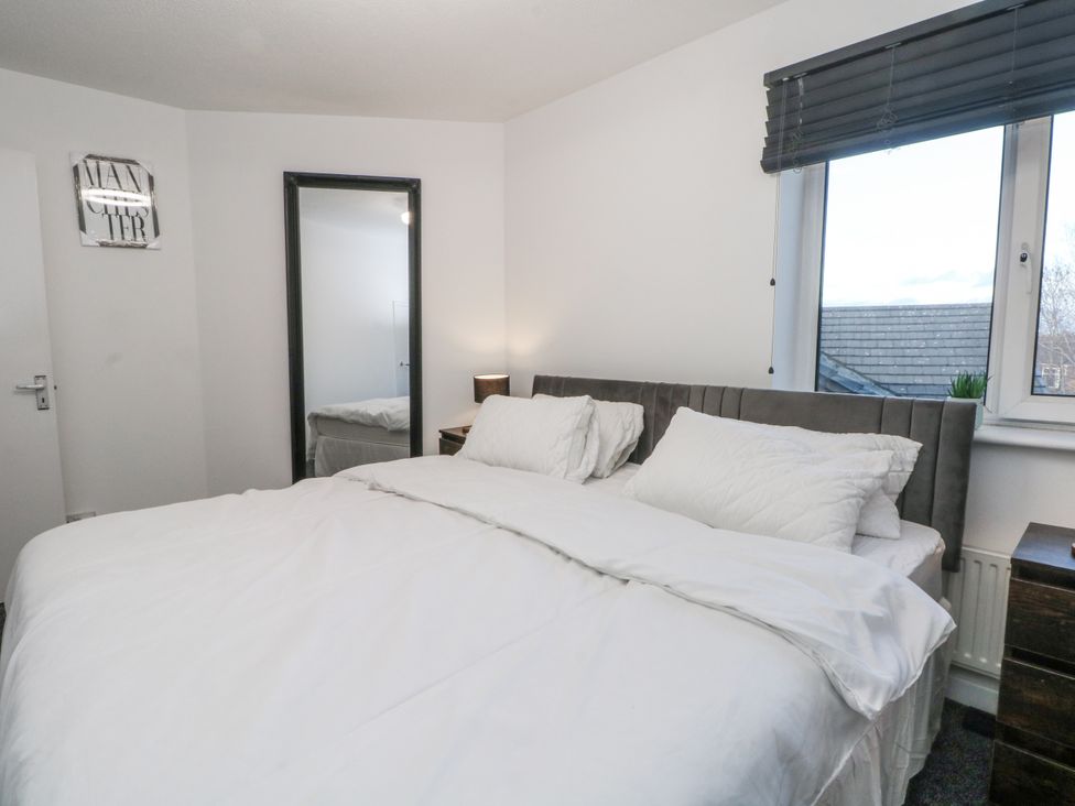 A bedroom with a bed and a mirror at Manchester apartment in Manchester