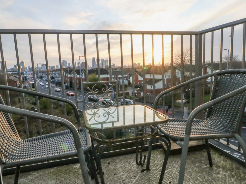 A balcony with chairs and a table at Manchester apartment in Manchester