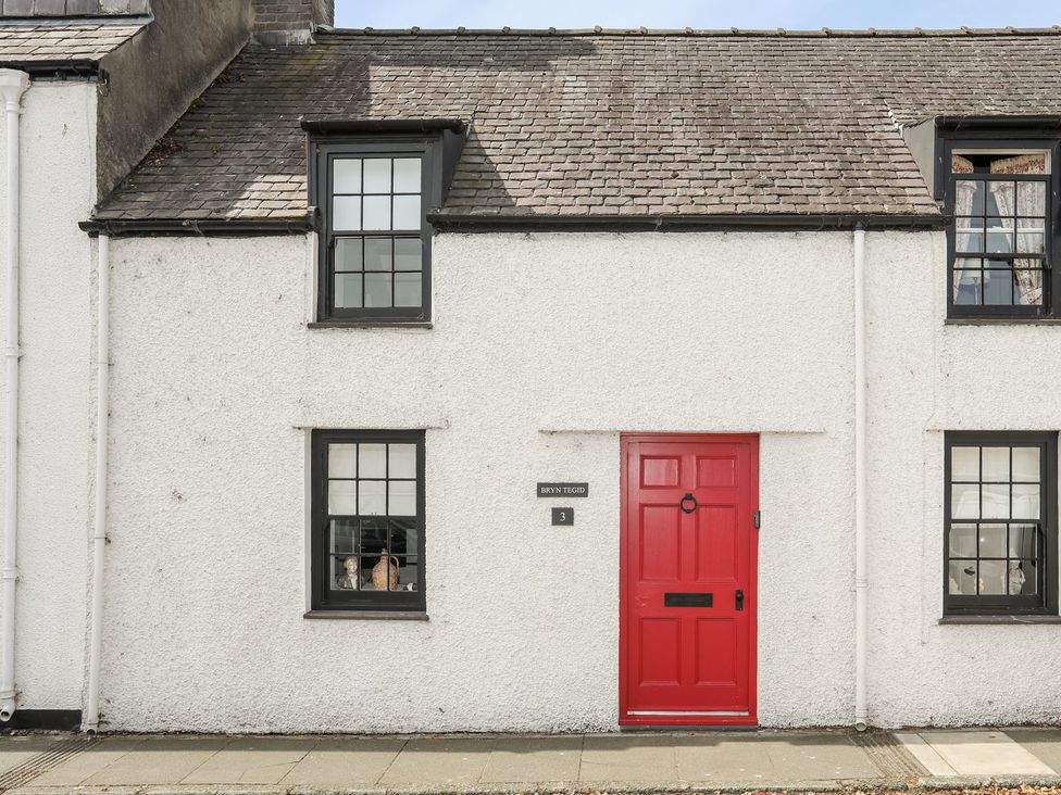 A house with a red door and windows at Bryn Tegid in Beaumaris