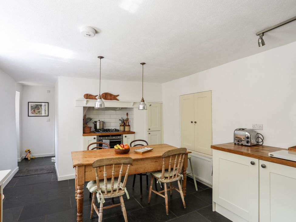 A kitchen with a wooden table and chairs at Bryn Tegid in Beaumaris