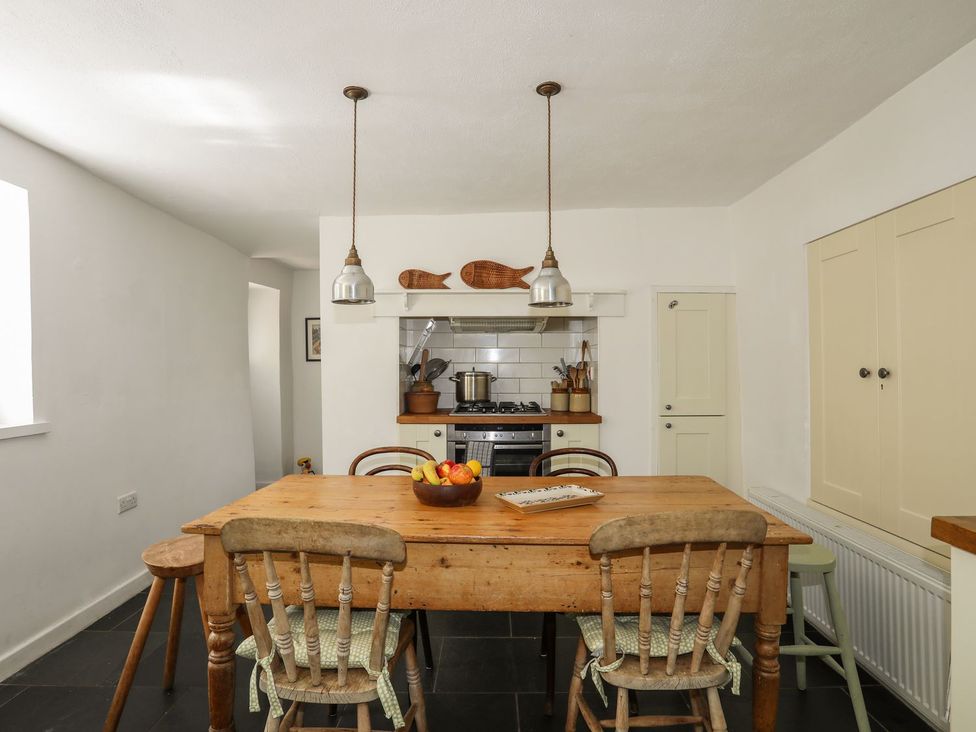 A kitchen with a wooden table and chairs at Bryn Tegid in Beaumaris