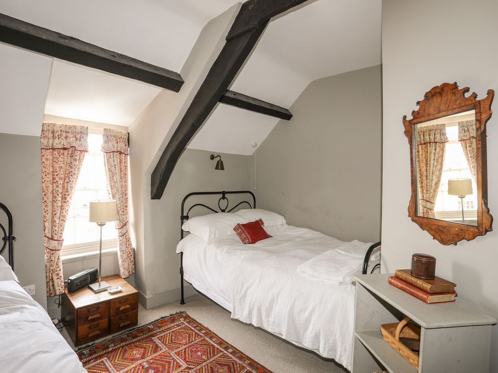A bedroom with two beds and a nightstand at Bryn Tegid in Beaumaris