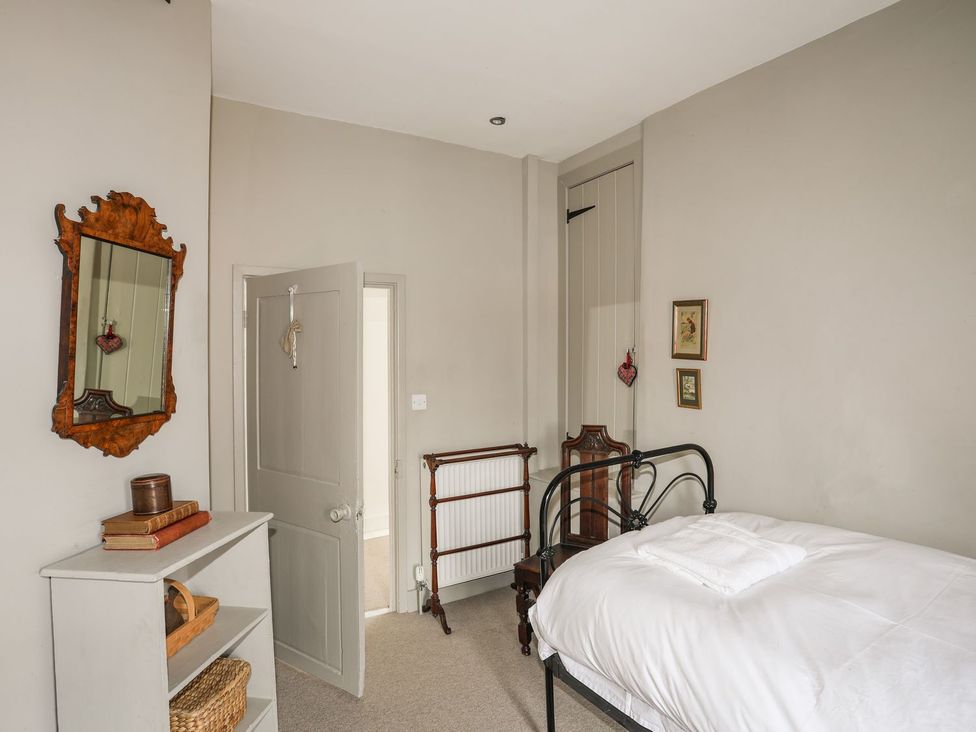 A bedroom with a bed and a mirror at Bryn Tegid in Beaumaris