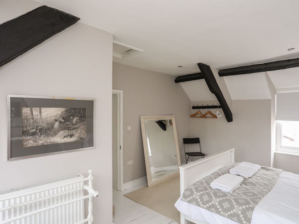 A bedroom with a bed and mirror at Bryn Tegid in Beaumaris