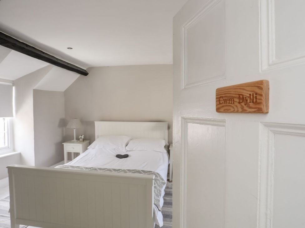 A bedroom with a bed and a bedside table at Bryn Tegid in Beaumaris