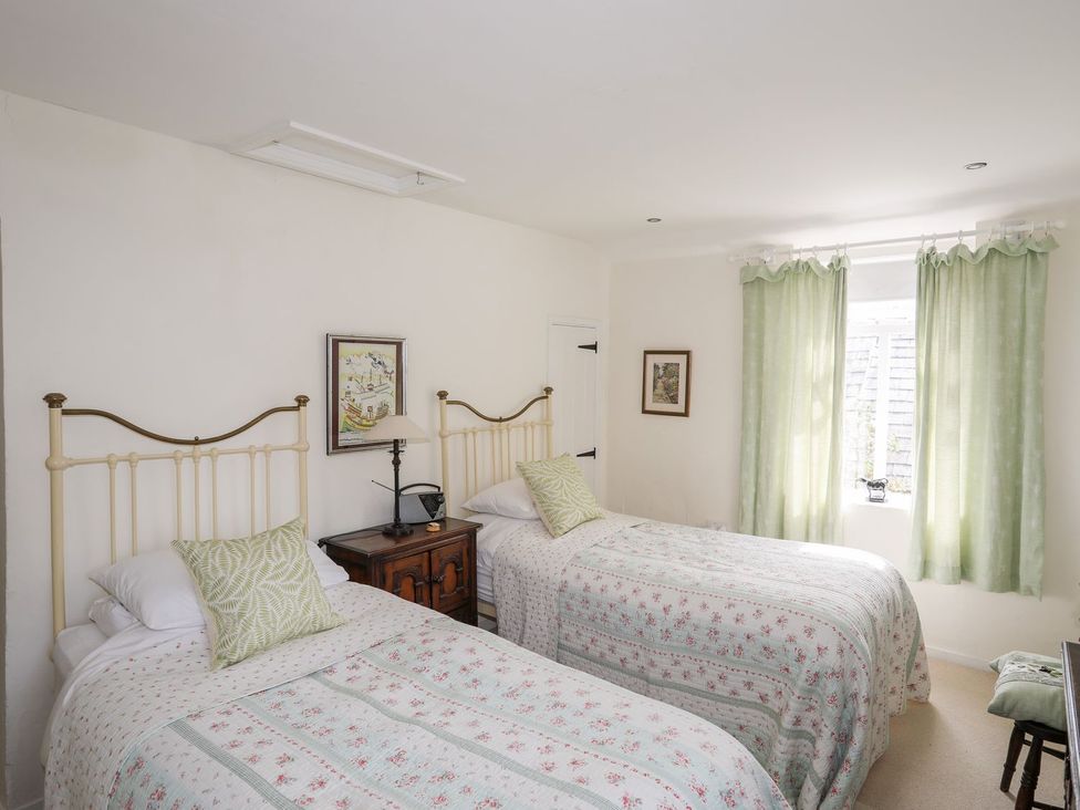 A bedroom with two beds and a window at Bryn Tegid in Beaumaris