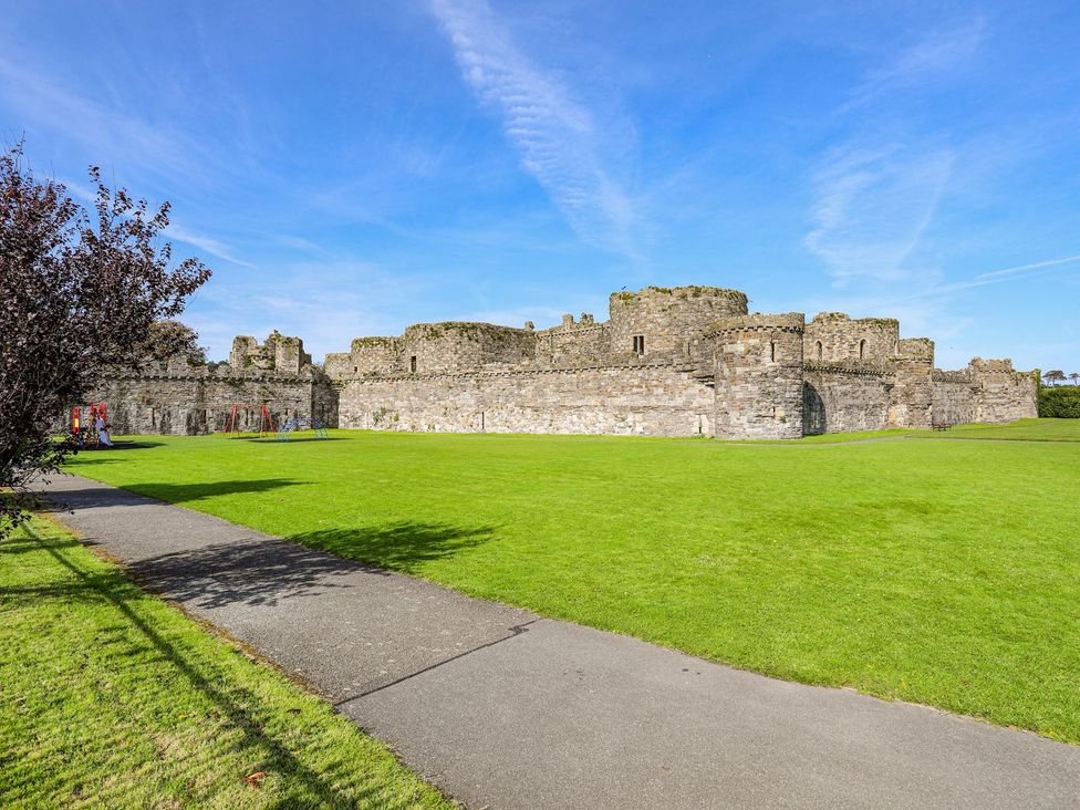 Castle ruins with grass and playground equipment in Beaumaris