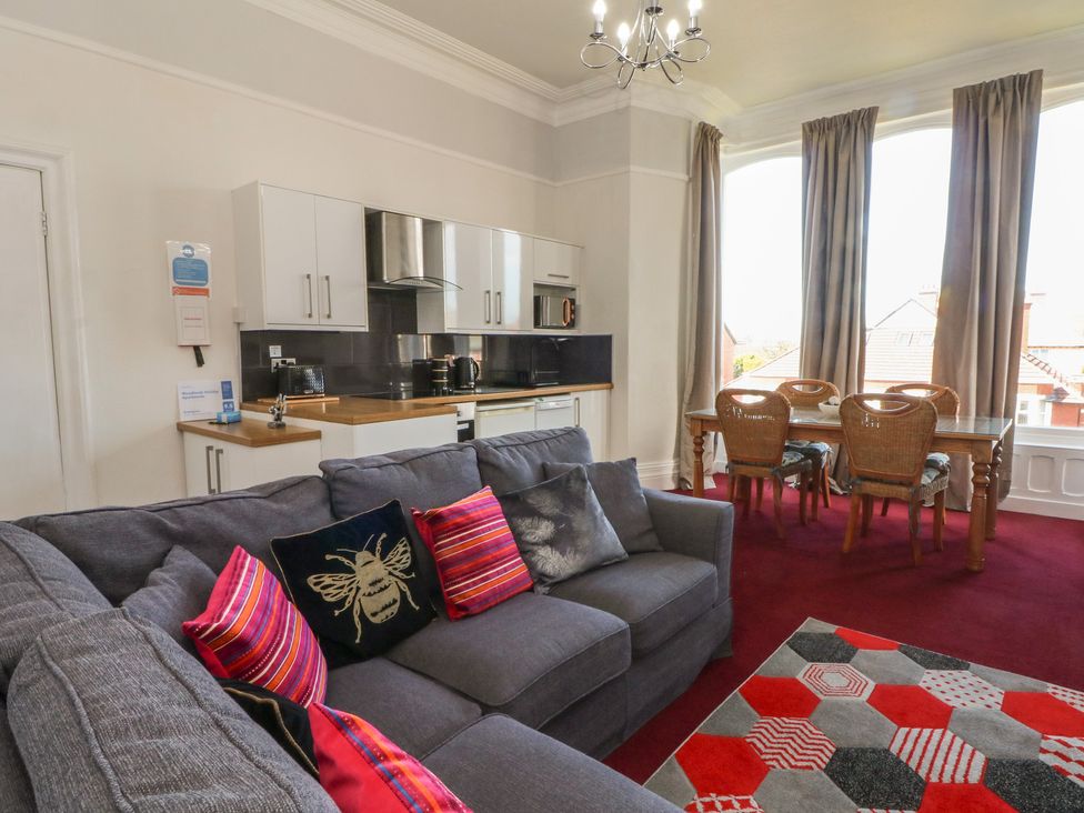A living room with a sofa and dining area at Apartment 1