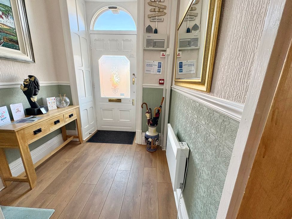 A hallway with a table and a mirror at Apartment 1 in Lytham St. Annes