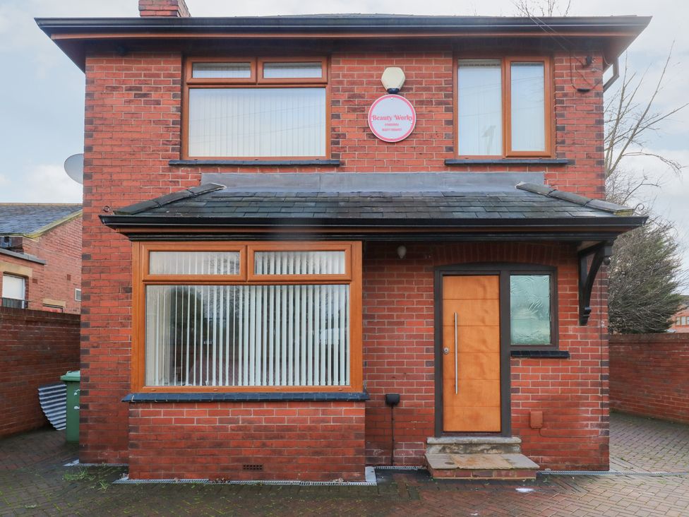 A house exterior with brick walls and large windows at Middleton Park House in Leeds