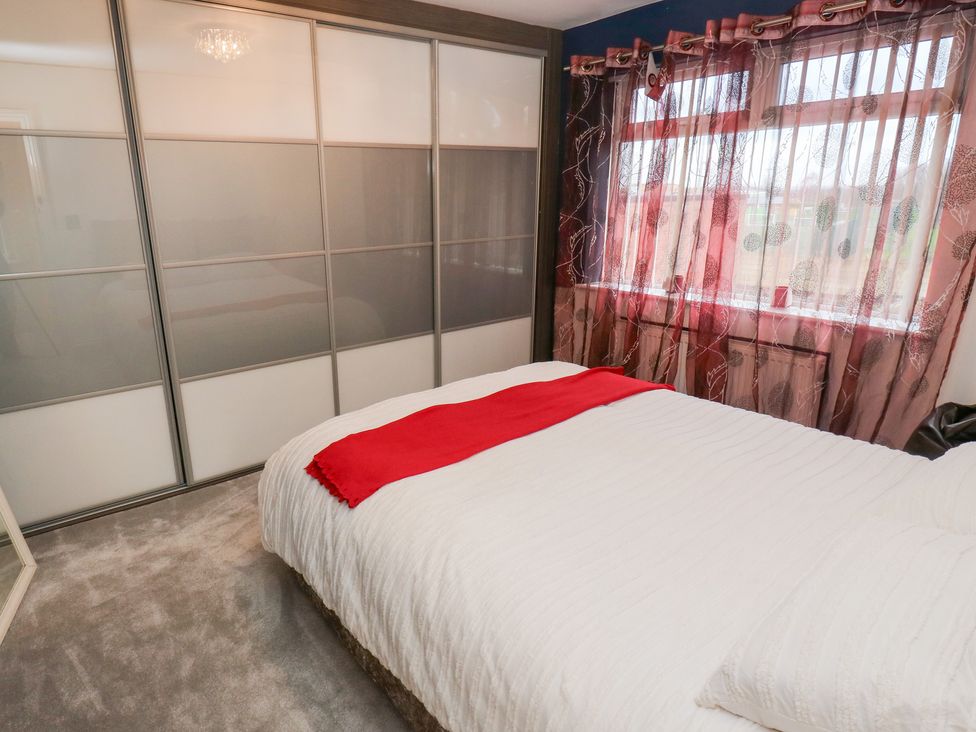 A bedroom with a bed and wardrobe at Middleton Park House in Leeds