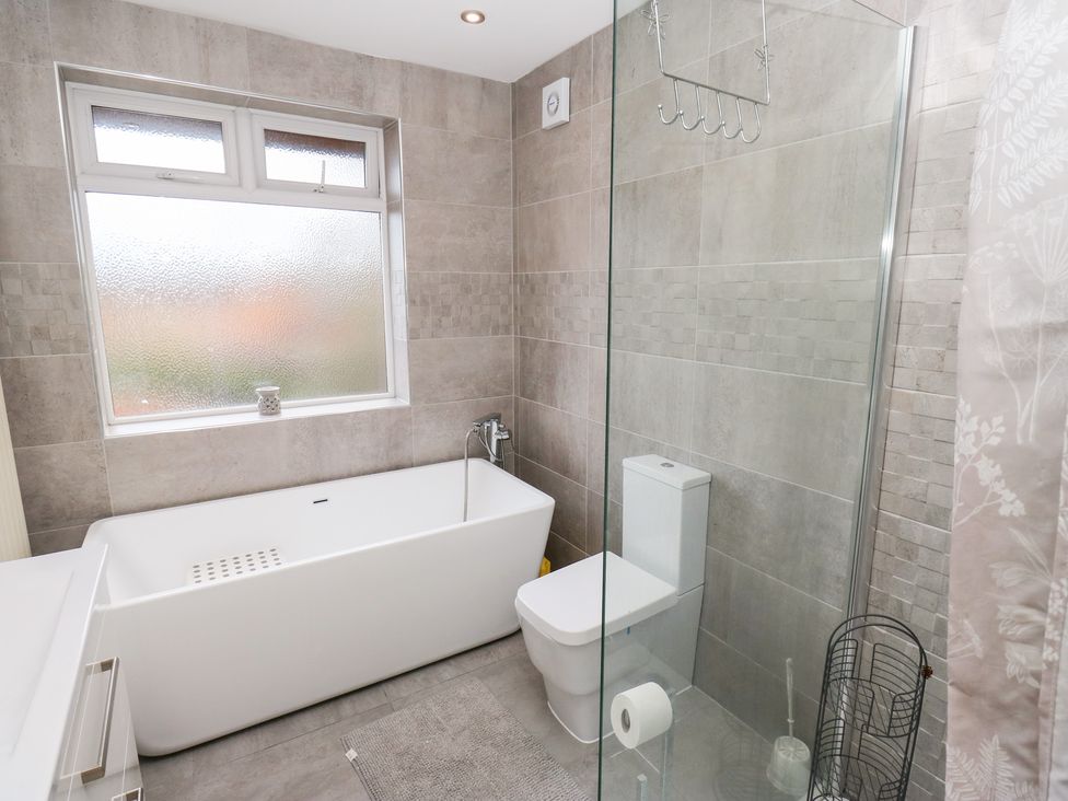 A bathroom with a bathtub and toilet at Middleton Park House Leeds