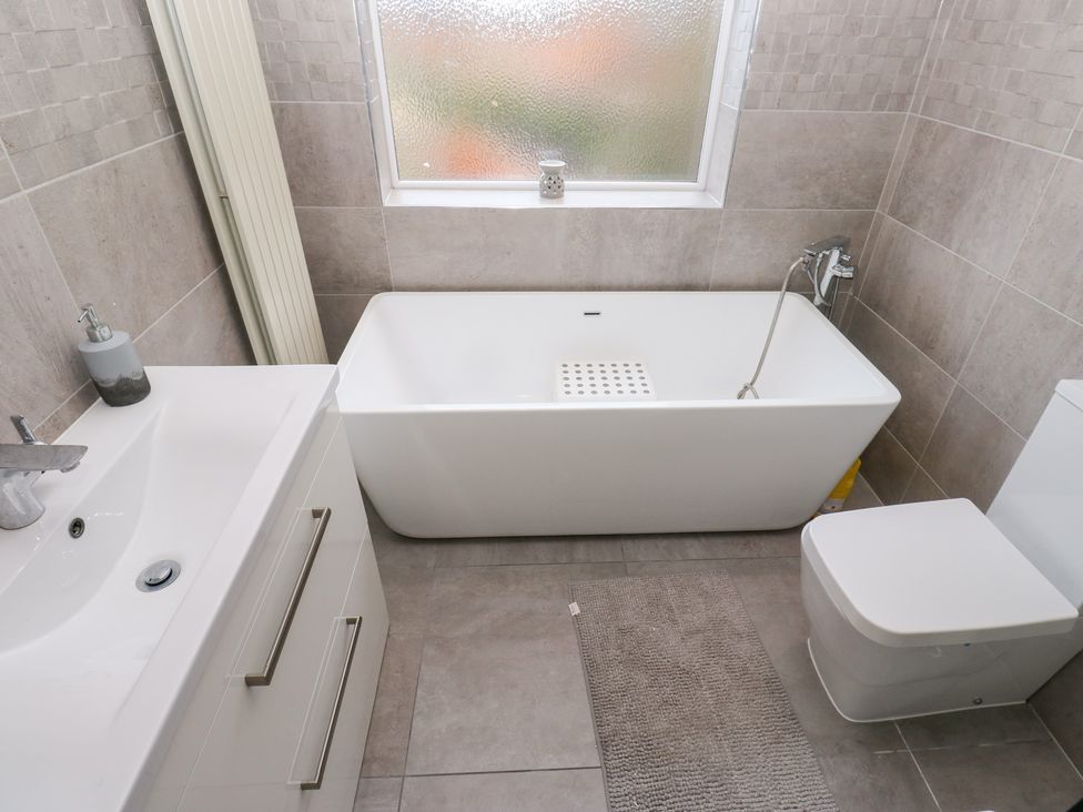 A bathroom with a bathtub, sink, and toilet at Middleton Park House in Leeds