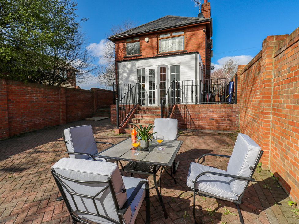 A garden with patio furniture and a house in the background at Middleton Park House in Leeds