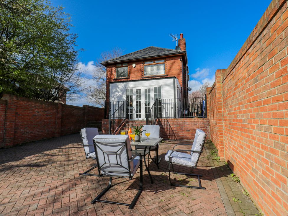 An outdoor seating area with a table and chairs at Middleton Park House in Leeds