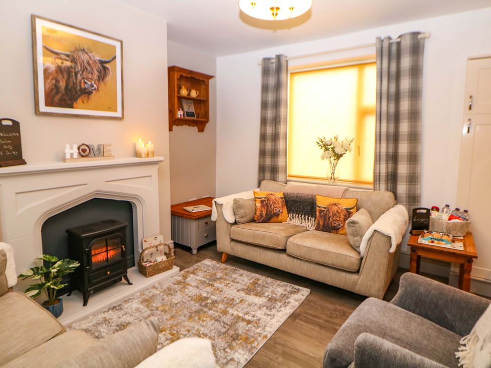 A living room with a couch, fireplace, and decorative items at Nightingale House Stafford