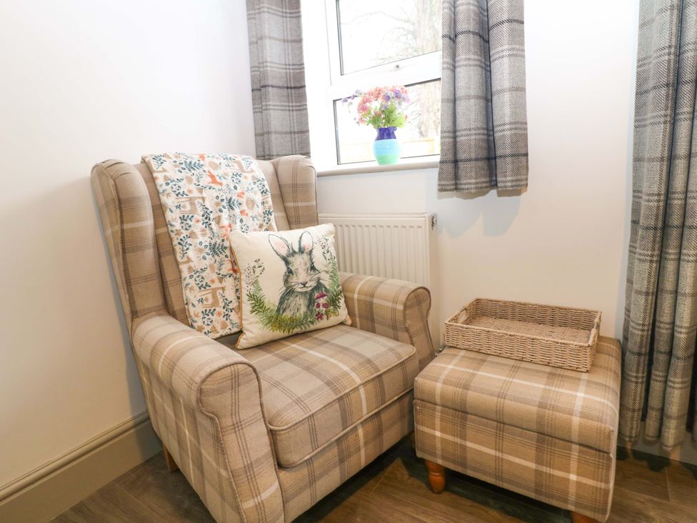 A snug with an armchair and cushion at Nightingale House Stafford
