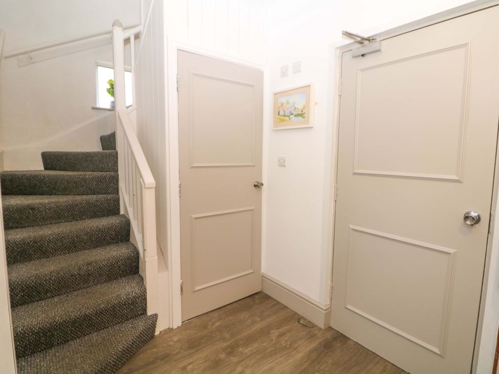 A hallway with a staircase and two doors at Nightingale House Stafford