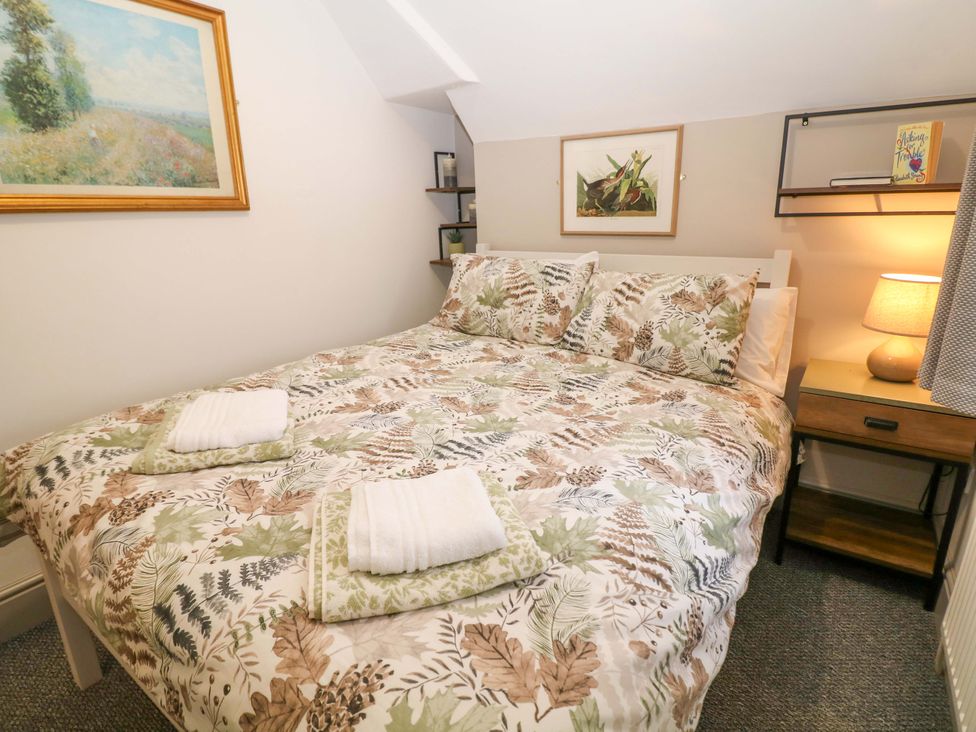 A bedroom with a double bed and bedside table at Nightingale House Stafford