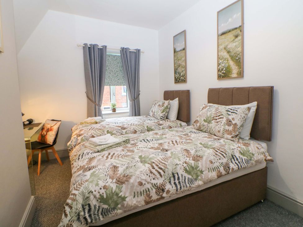 A bedroom with twin beds and a desk at Nightingale House Stafford