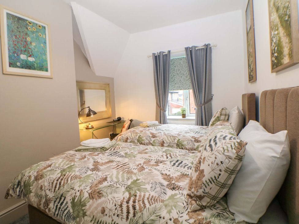 A bedroom with two beds and a mirror at Nightingale House Stafford