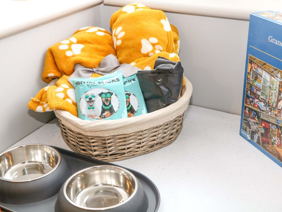 A basket with blankets and pet items beside dog bowls at Nightingale House in Stafford